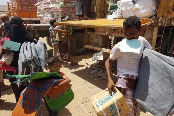 Yemen. UNHCR aid convoys reach Mokha Thousands of displaced Yemenis from villages in the district of Mokha receive mattresses, sleeping mats, blankets, kitchen sets and wash buckets at a UNHCR distribution point. ; After weeks of negotiations, UNHCR reached the district of Mokha in Yemen’s western governorate of Taizz on 20 March 2017. Hostilities between the warring parties have escalated here since the beginning of the year and the intensified fighting has led to tens of thousands being forcibly displaced. UNHCR teams distributed emergency aid to over 3,400 people in the first few days after gaining access. Many are traumatised and living in desperate conditions, lacking water and sanitation. At the time these pictures were taken, two million people were displaced across Yemen and one million had returned home to precarious conditions. Despite the desperate human suffering, by late-March 2017 UNHCR had received less than $10 million of the $99 million it needs to respond to the looming humanitarian catastrophe. We are appealing for urgent international support.